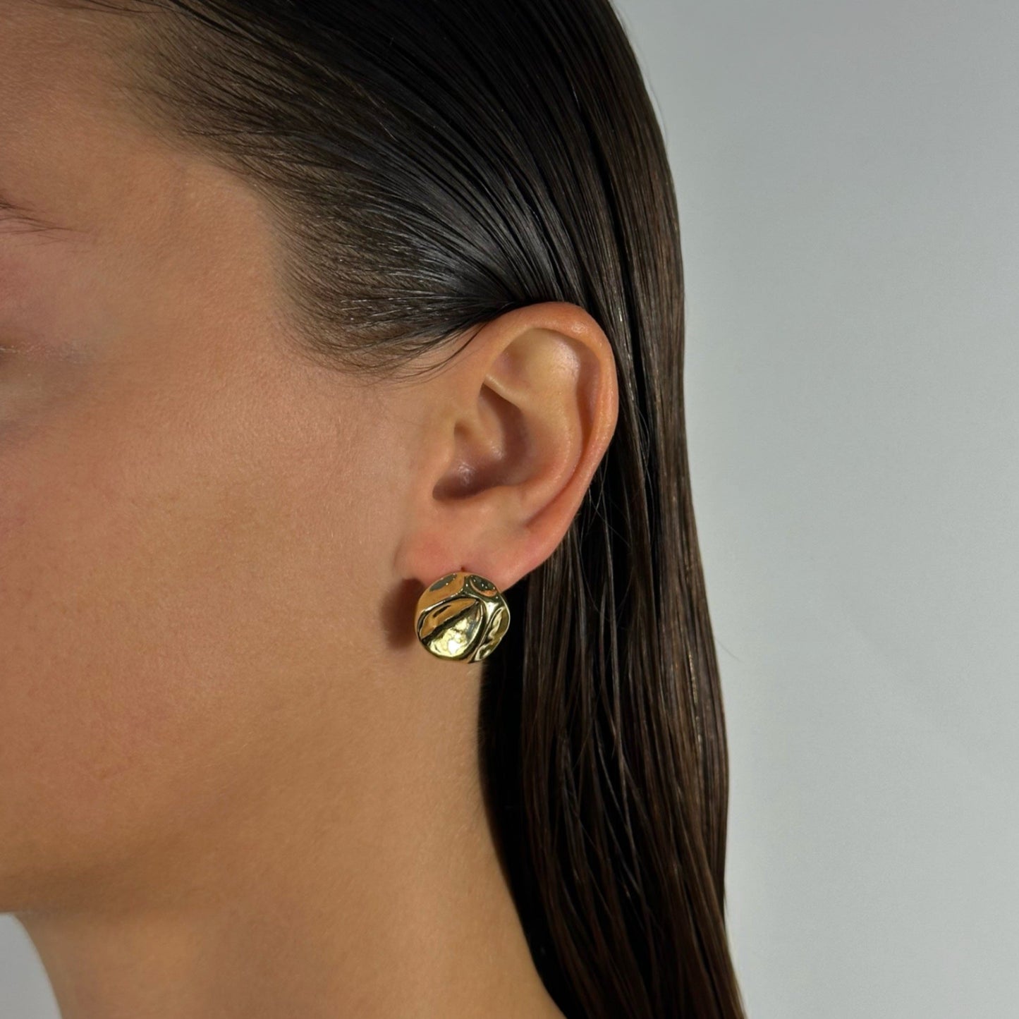 woman wearing 14k gold molten hammered classic stud earrings