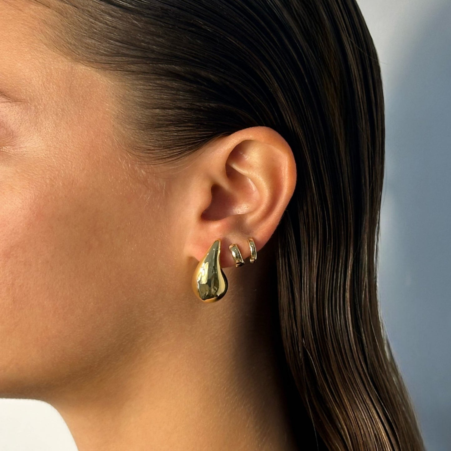 woman wearing 14k gold teardrop statement earrings