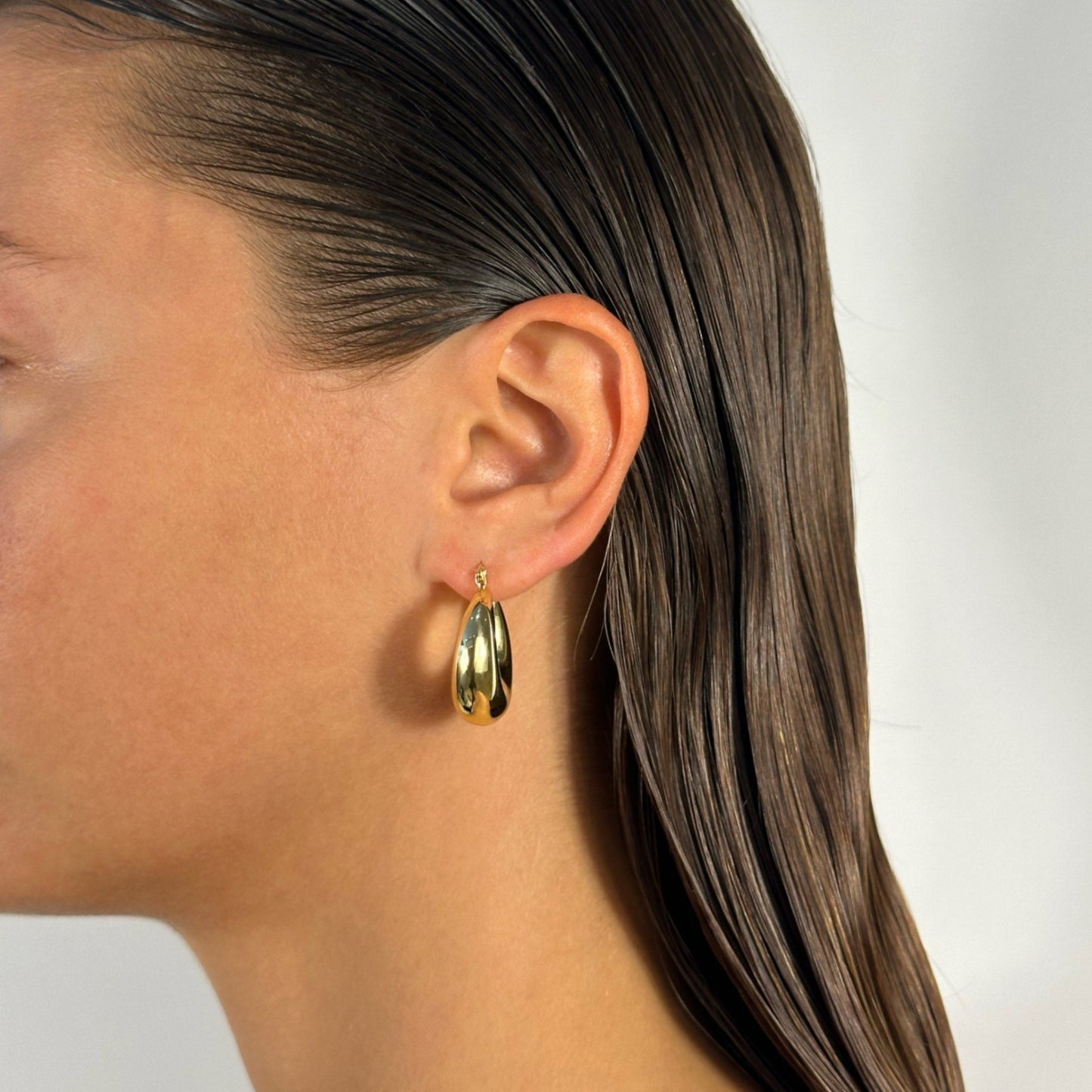 lady wearing gold chubby hoop earrings