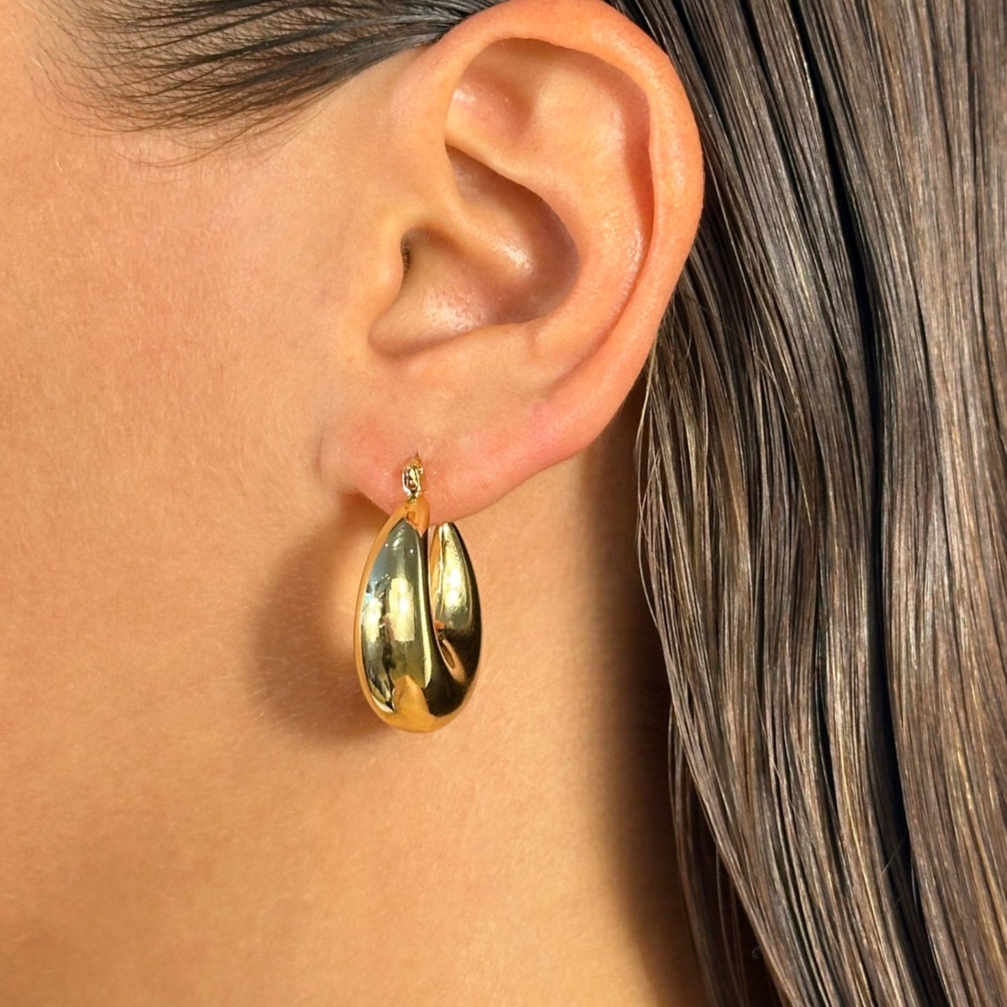 lady wearing gold chubby hoop earrings