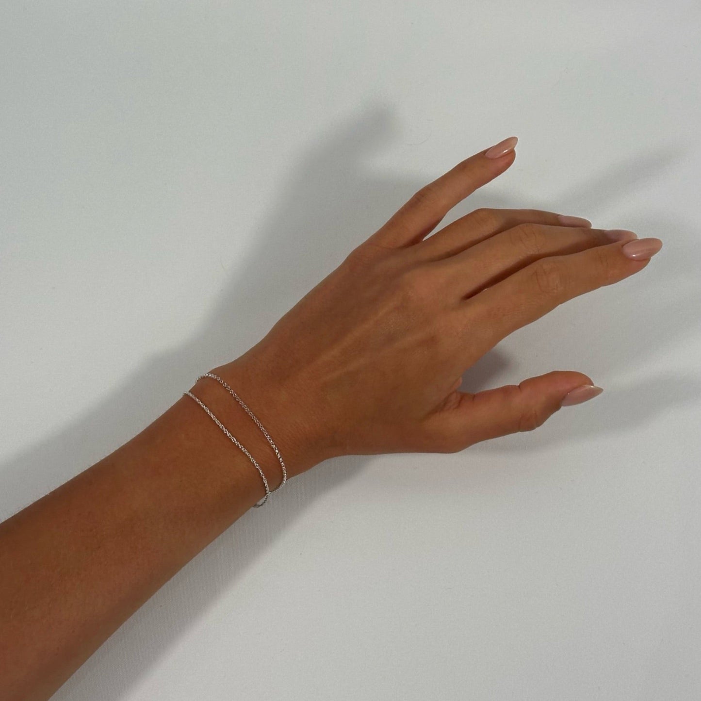 lady wearing sterling silver classic fine rope rolo chain bracelets