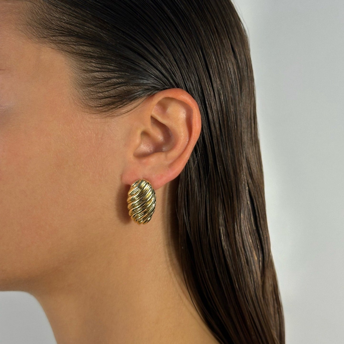 woman wearing 14k gold oval croissant lined statement classic earrrings 
