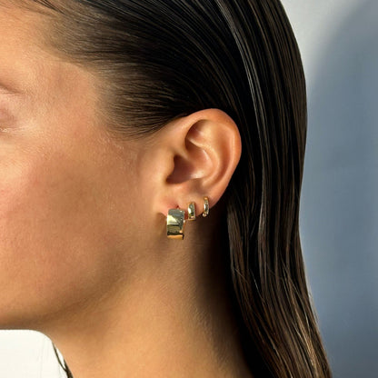 woman wearing 14k gold statement classic timeless wide dome triangle hoop earrings