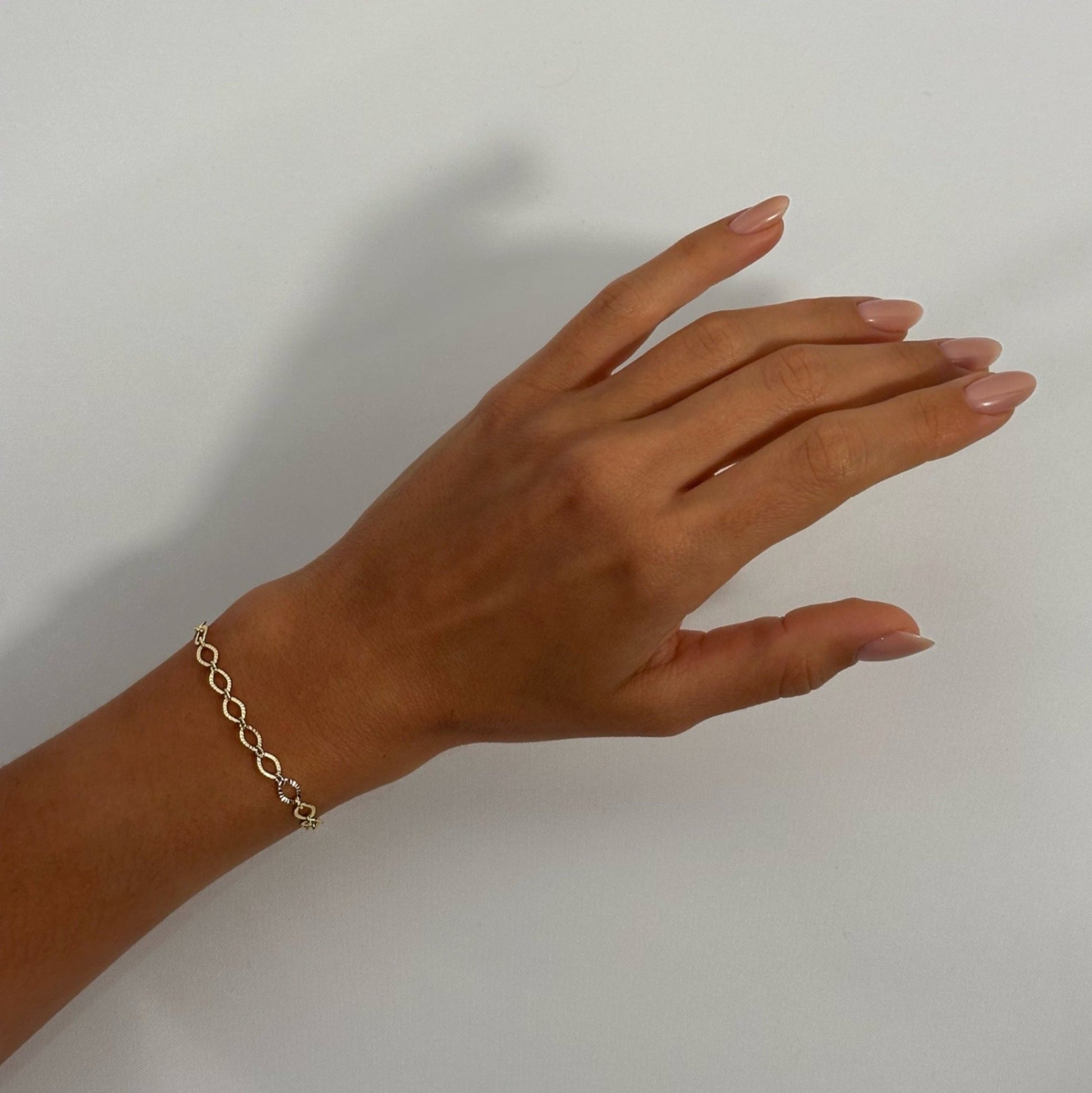 woman wearing 14k gold timeless dainty classic textured oval chain bracelet