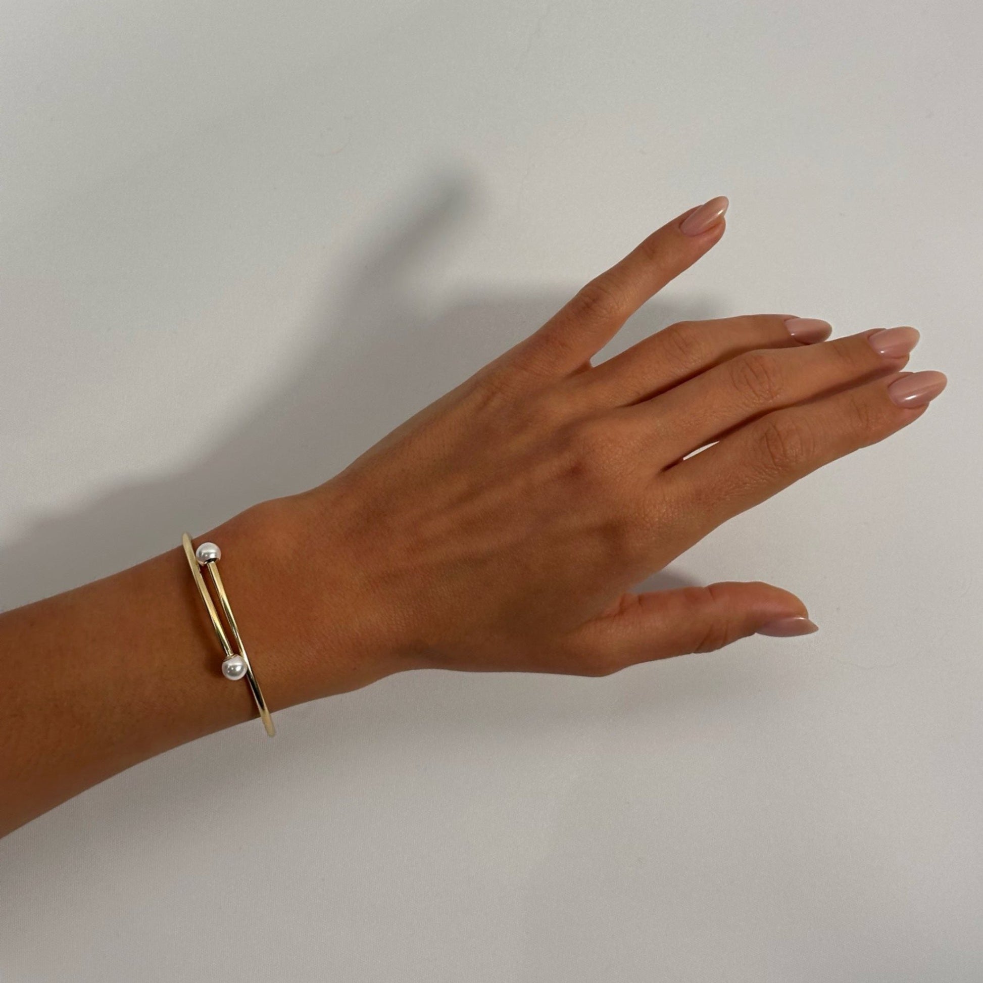 woman wearing 14k gold timeless pearl detail bangle