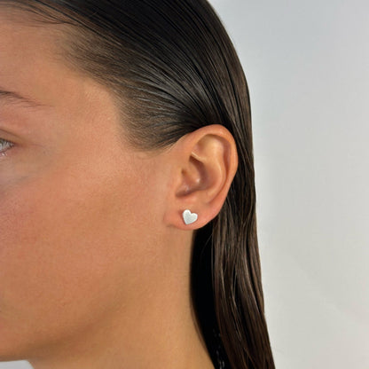 lady wearing classic dainty sterling silver heart shaped studs
