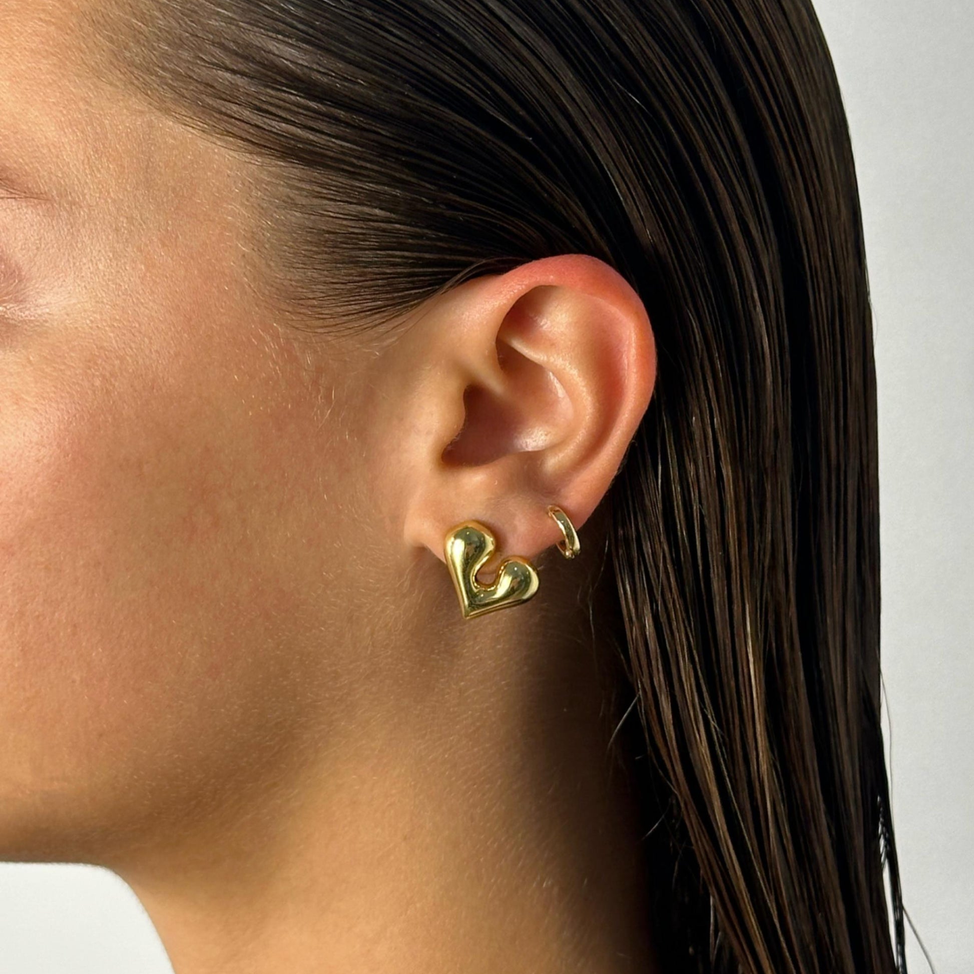 lady wearing gold abstract heart earrings 