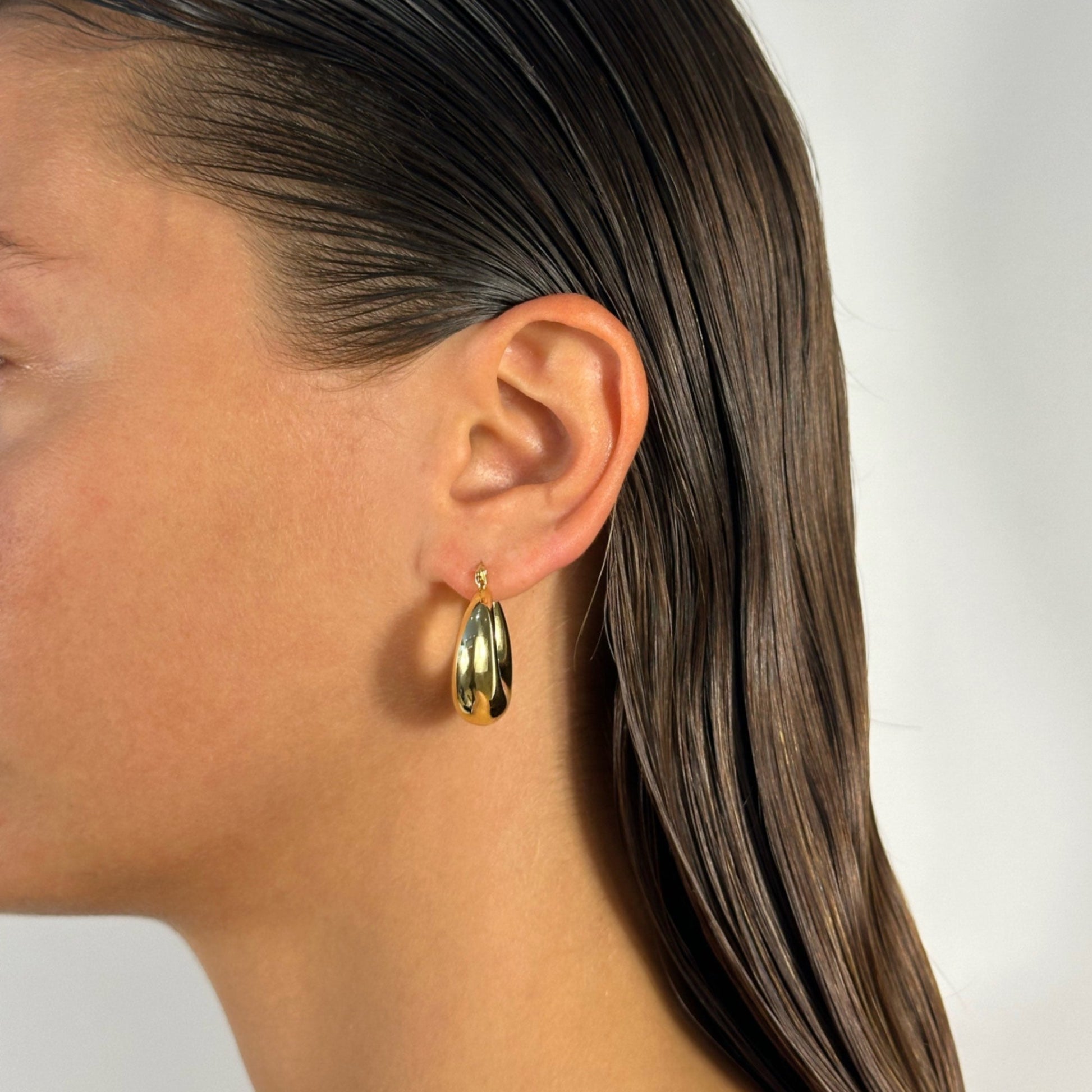 lady wearing gold chubby hoop earrings