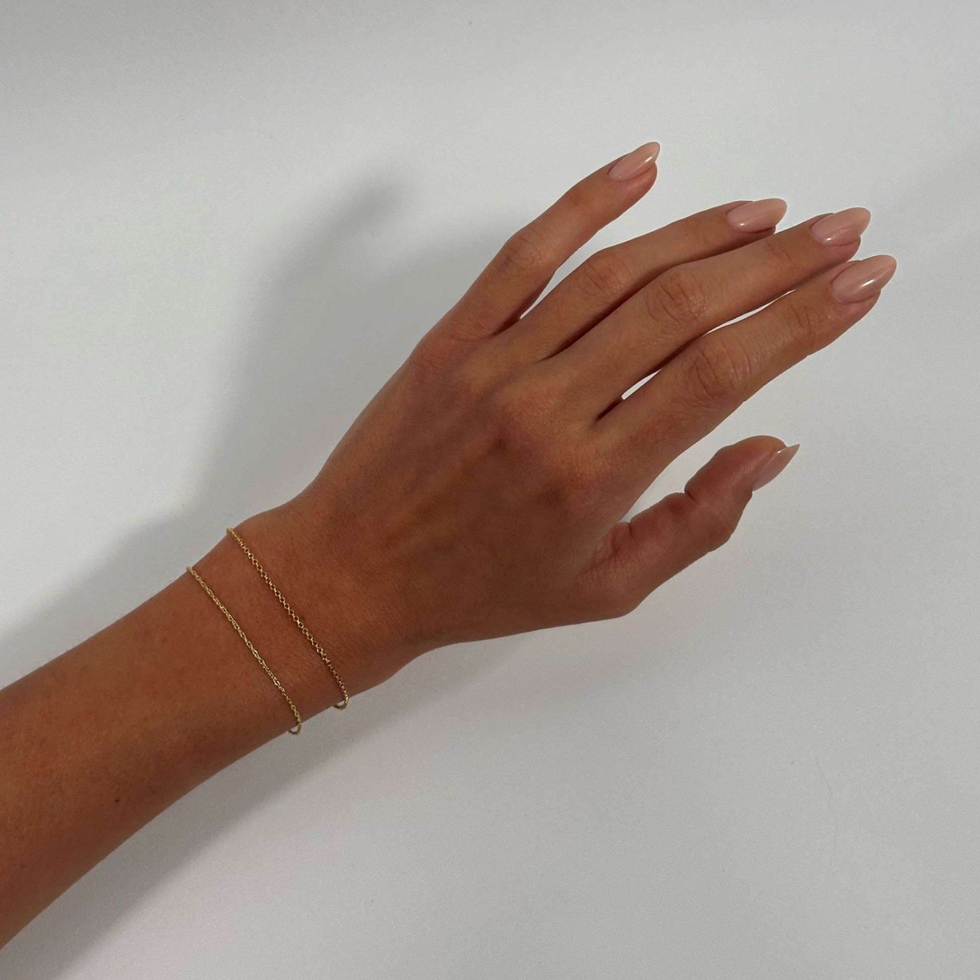 lady wearing gold classic fine rope rolo chain bracelet