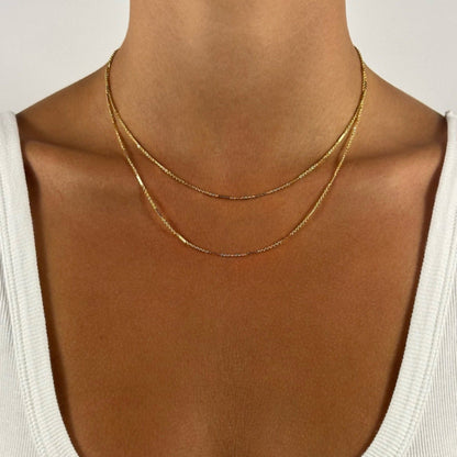 lady wearing gold dainty dapped cable necklace
