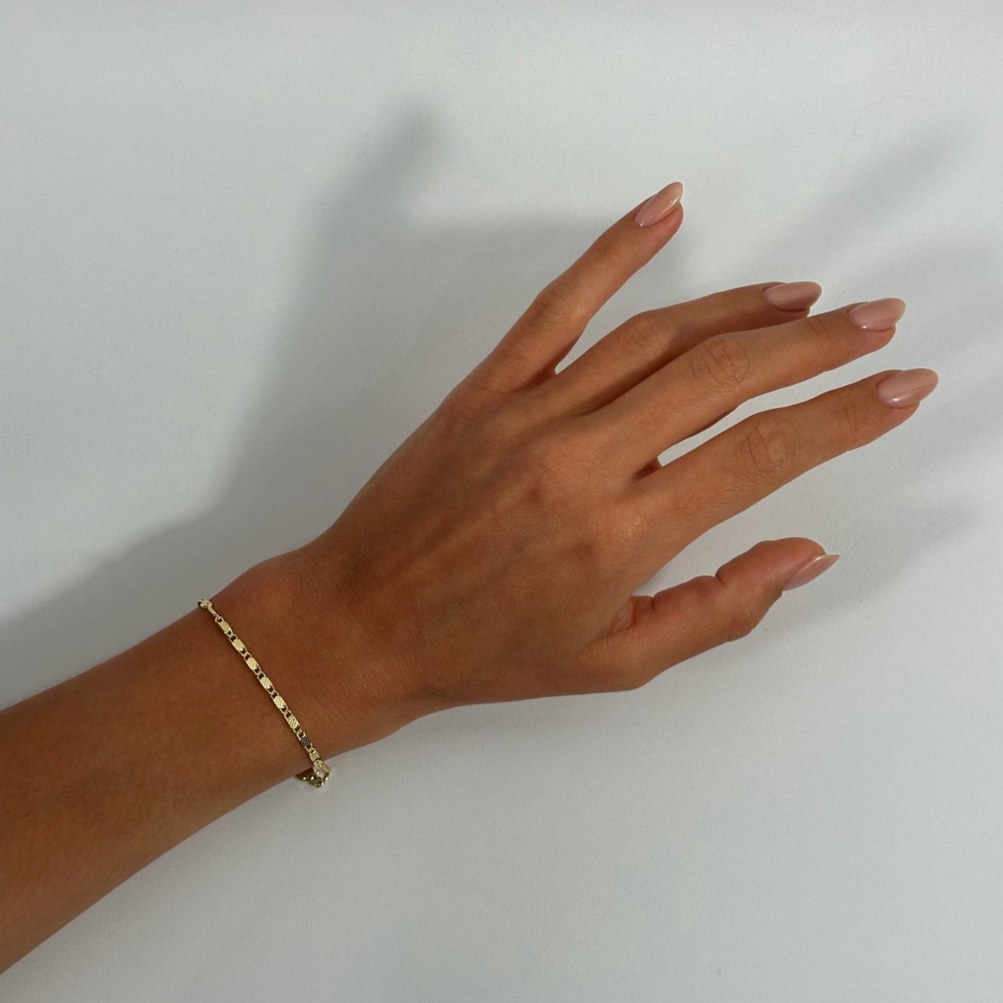 lady wearing gold dainty dotted scroll bracelet