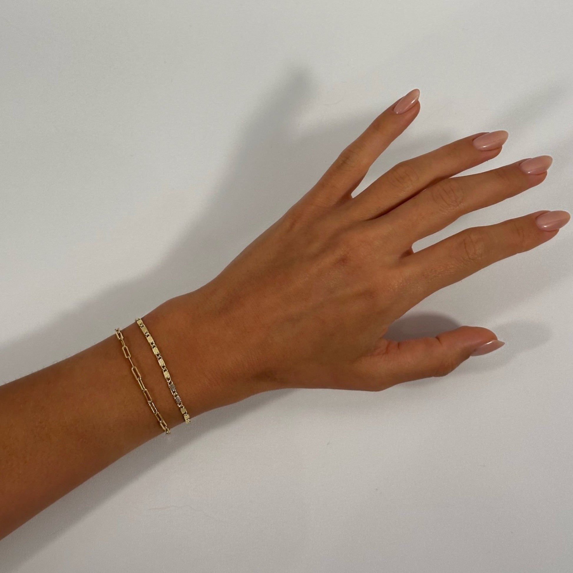 lady wearing gold dainty dotted scroll cable bracelet
