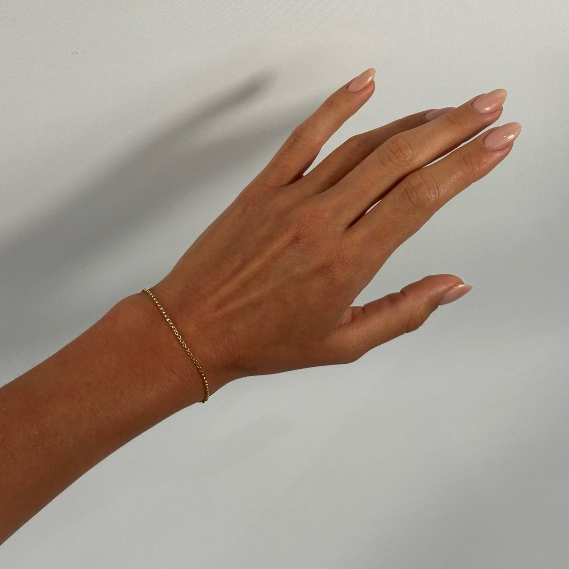 lady wearing gold dainty fine rolo chain bracelet