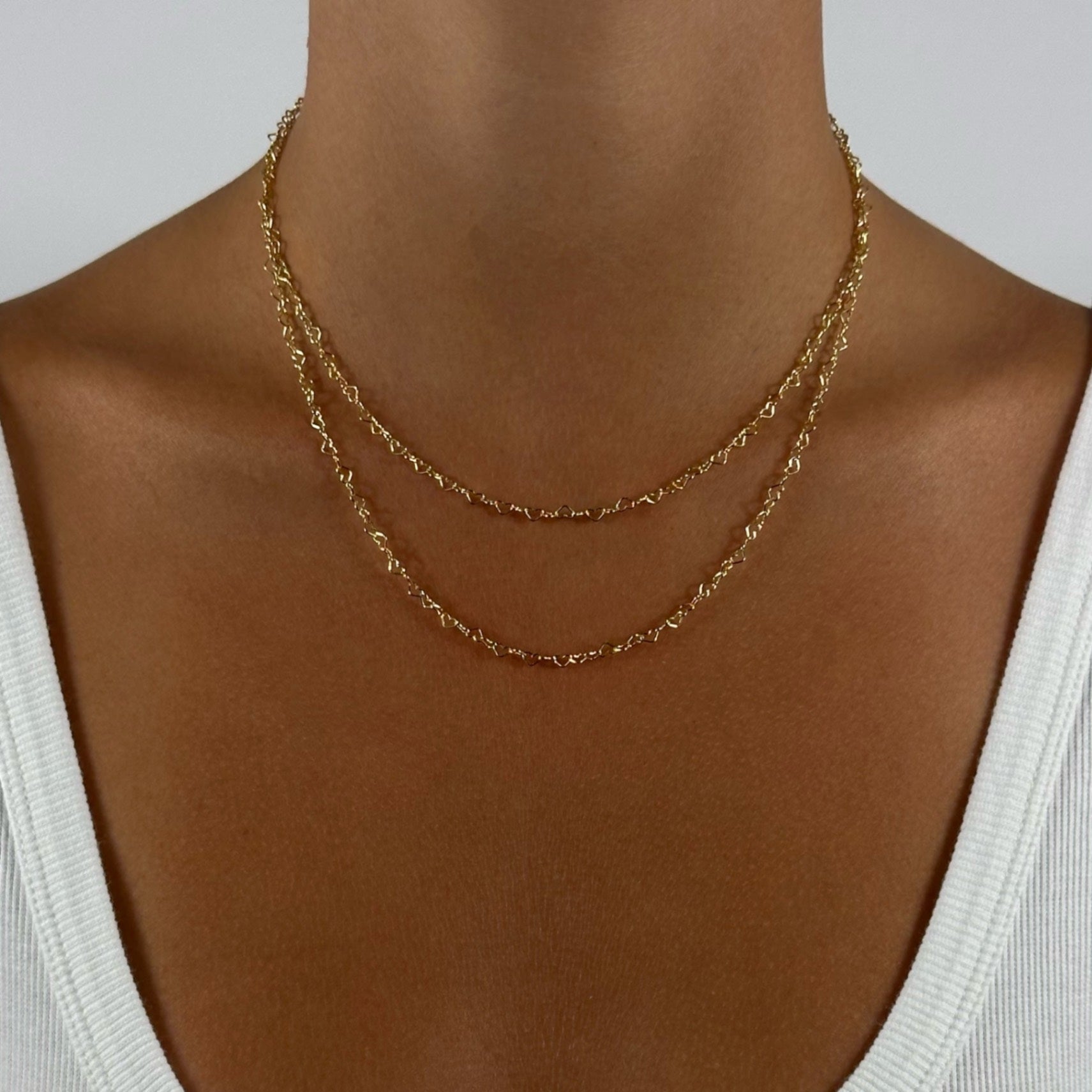woman wearing gold dainty heart chain necklace