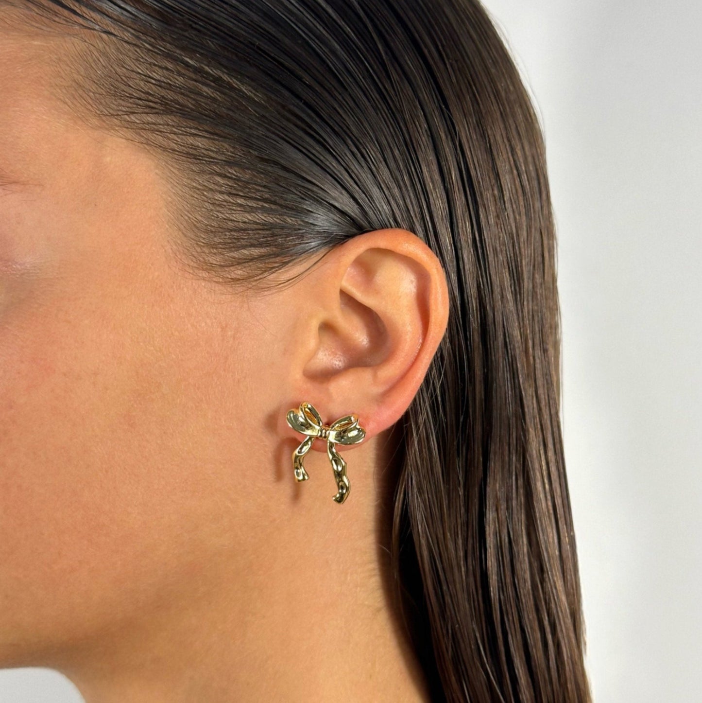 lady wearing gold bow earrings 