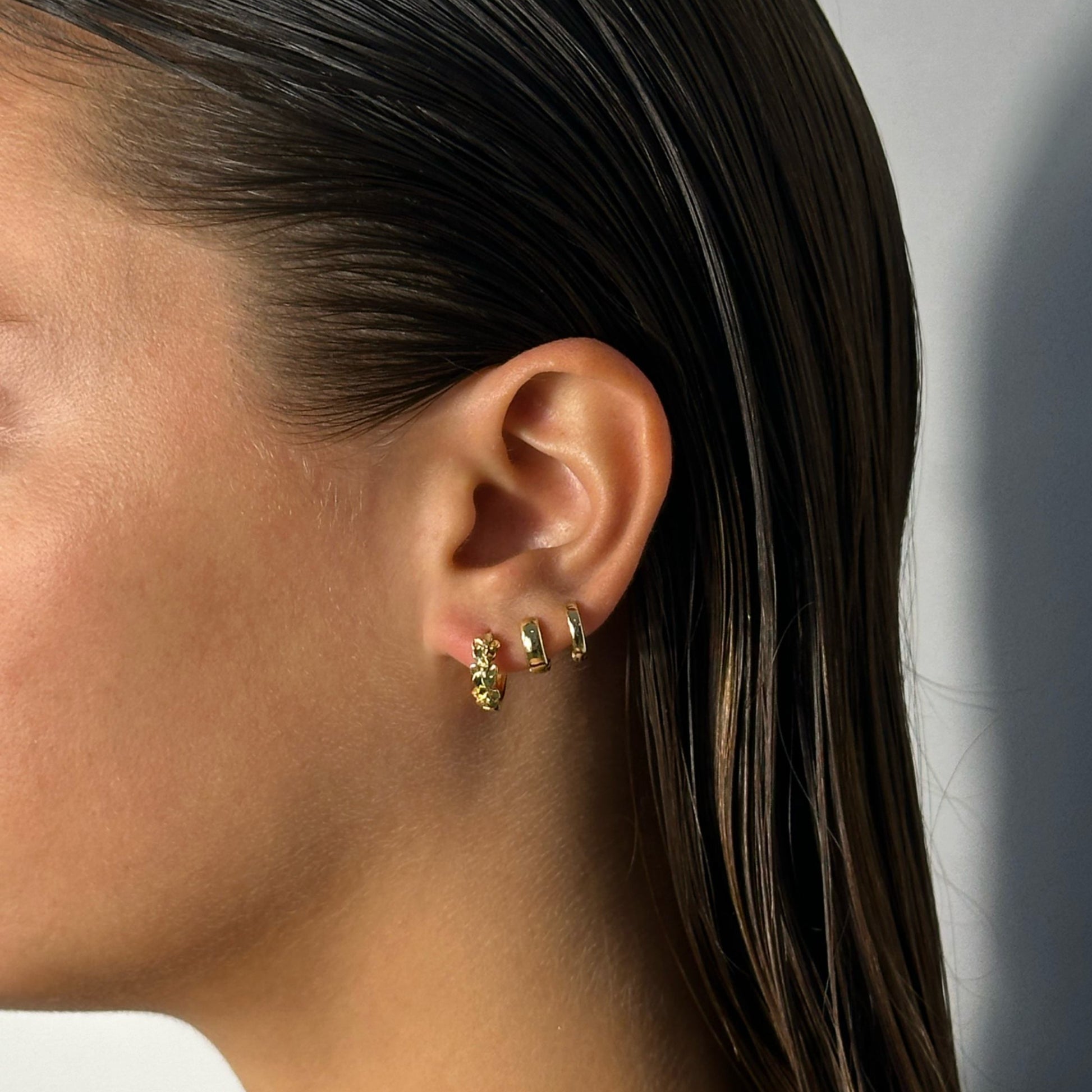 lady wearing gold flower cubic zirconia detail hoops