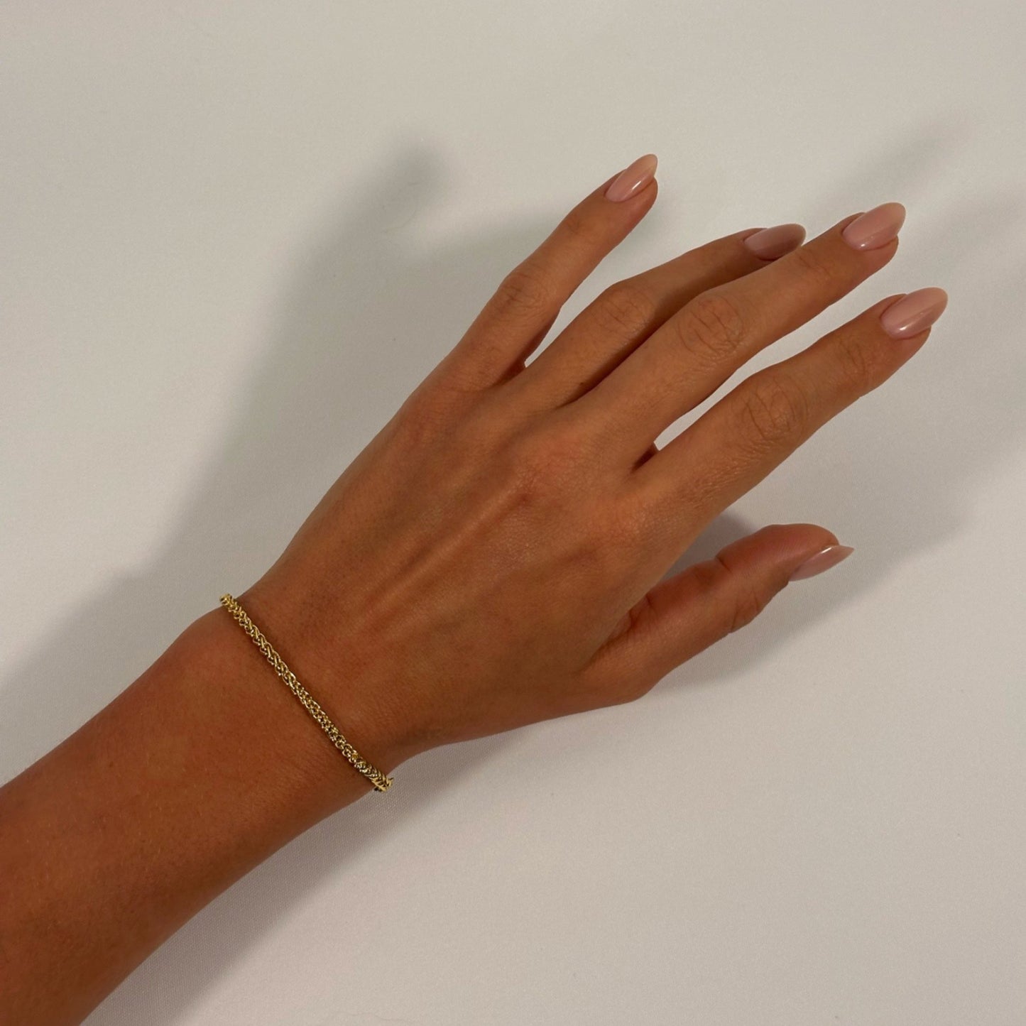 lady wearing gold foxtail chain bracelet 