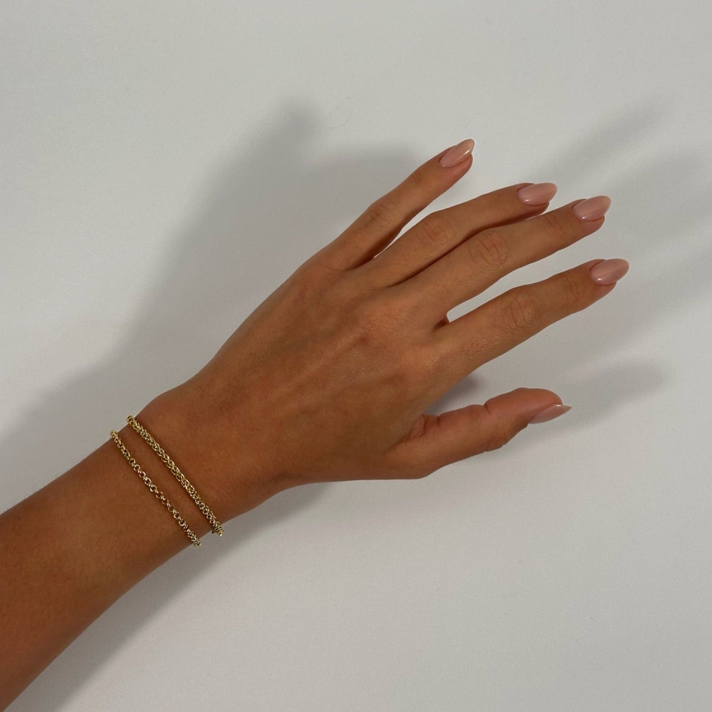 lady wearing gold foxtail chain bracelet rolo bracelet