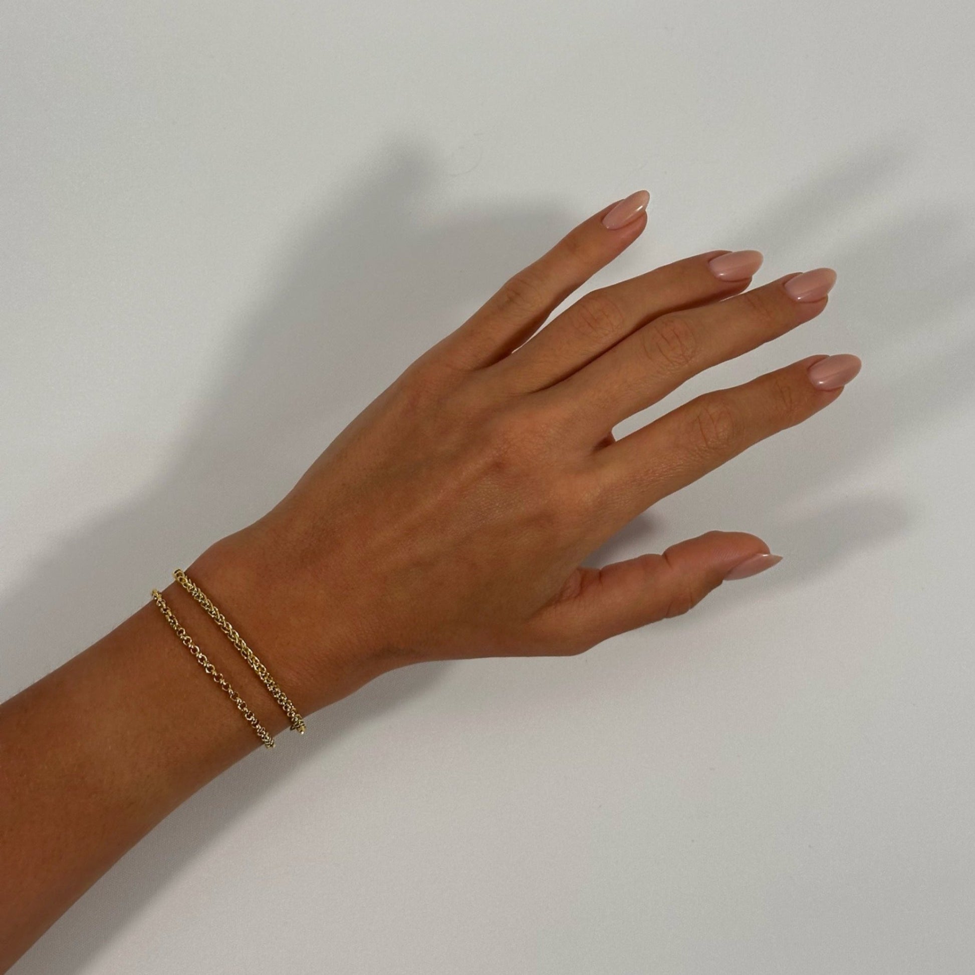 lady wearing gold foxtail chain bracelet rolo bracelet