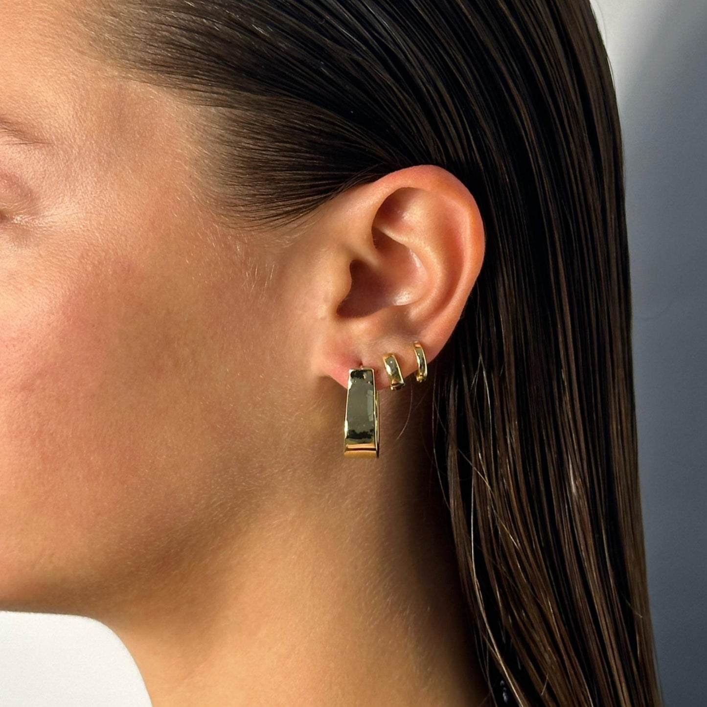 lady wearing gold geometric drop hoop earrings